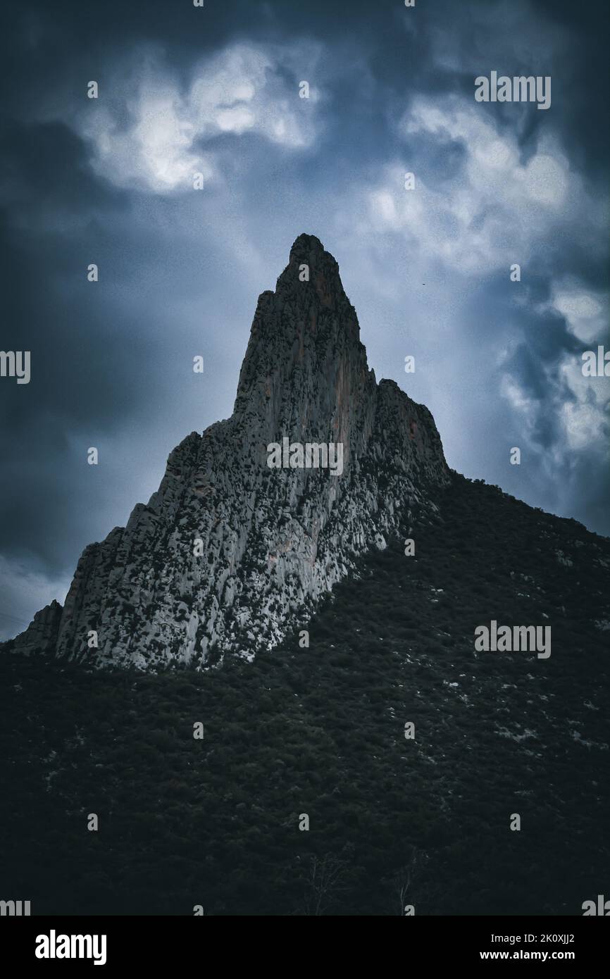 A dramatic shot of a mountain at La Huasteca national park against a gray cloudy sky Stock Photo