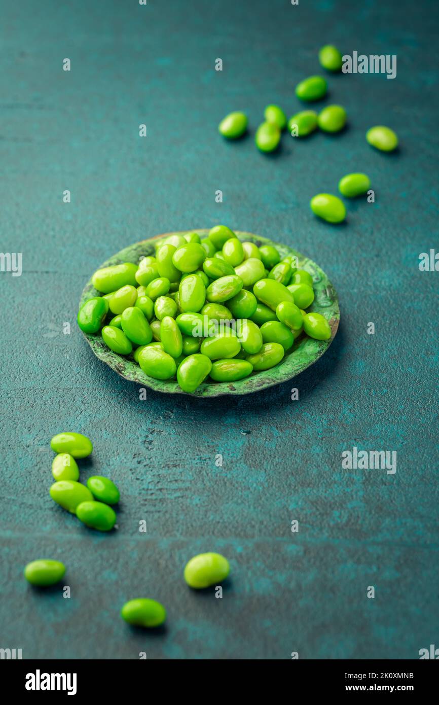Bowl of raw edamame beans on cyan background Stock Photo Alamy