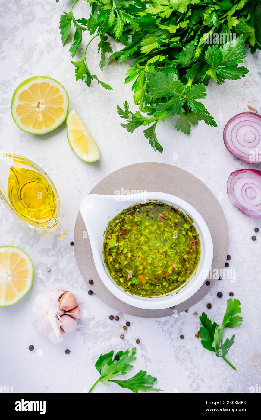 Chimichurri - homemade fresh Latin American sauce made from various herbs, garlic and red wine vinegar. Cooking ingredient or table condiment Stock Photo