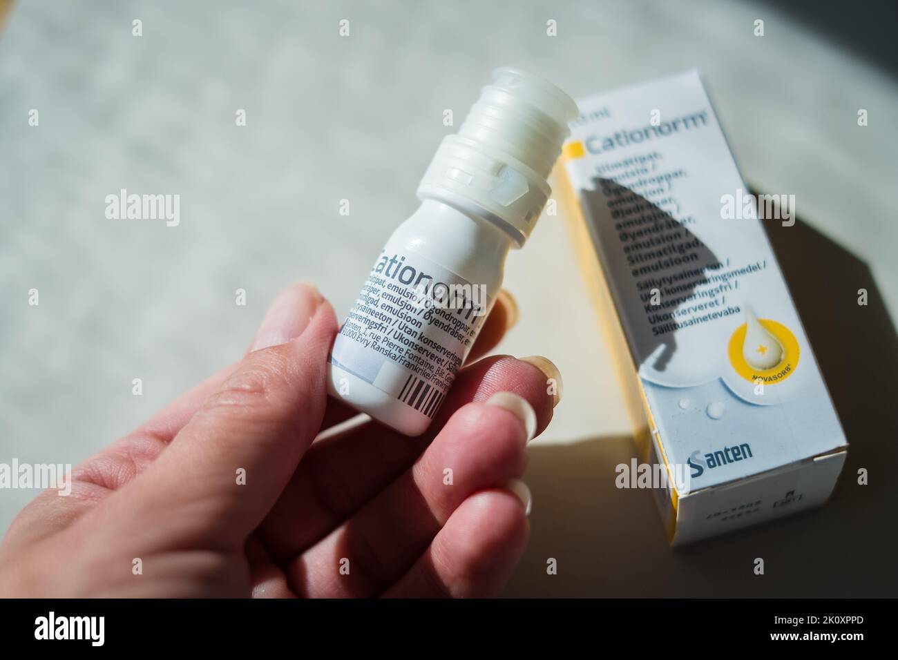 Hand holding Cationorm Eye drops by Santen to moisturize and soothe dry