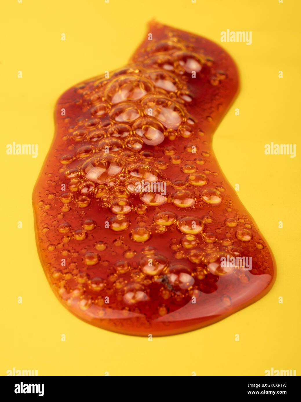 piace golden dab concentrate of cannabis wax close up on yellow background, marijuana resin. Stock Photo