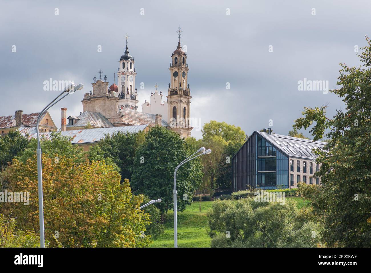 View of the Church of Ascension with a modern building in Scandinavian style and park on the green hill, Vilnius, Lithuania Stock Photo