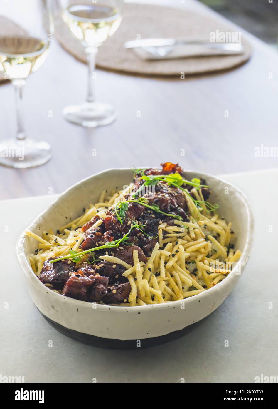 Spiced Pork Poke Bowl with Coconut Rice, Straw Potatoes, and Ginger Teriyaki Stock Photo