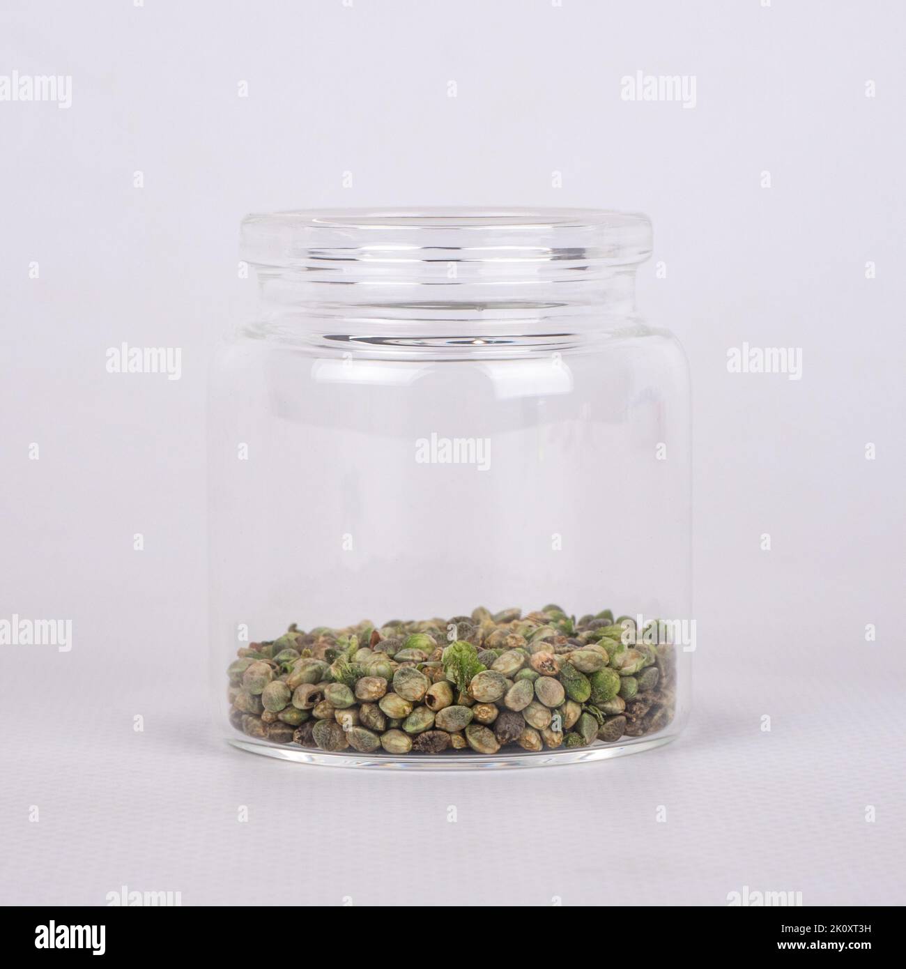 cannabis seeds in glass jar closeup, hemp natural grain. Stock Photo