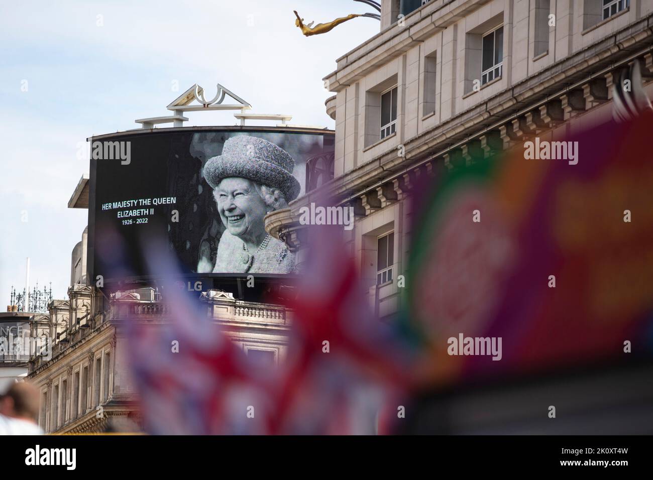 LONDON, UK - September 2022: A portrait of Queen Elizabeth II is shown on a large screen in Piccadilly Circus after her death Stock Photo