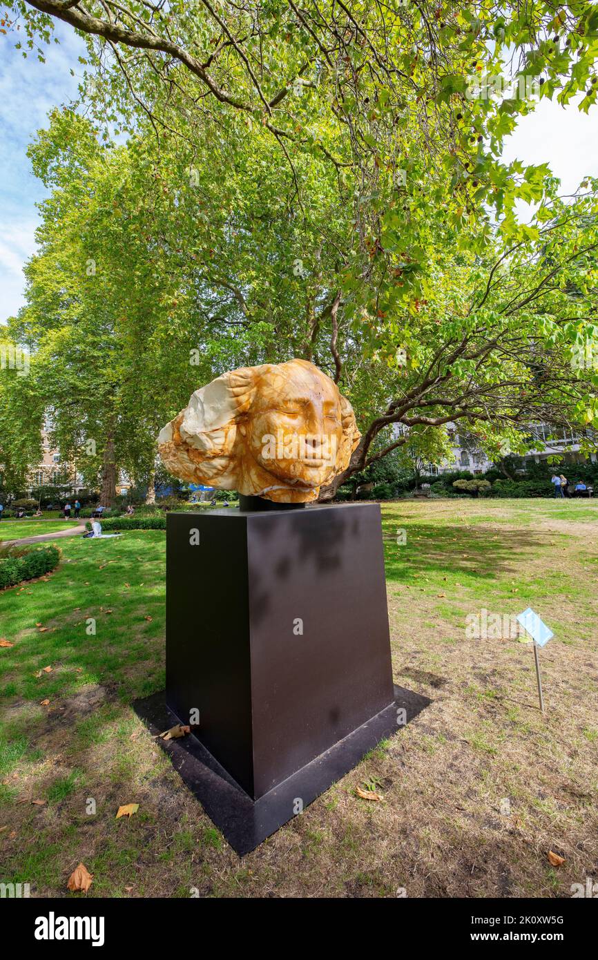 The Sun King Dreams of Peace, a 2022 sculpture in Giallo di Siena marble by Emily Young, placed in St James Square, London Stock Photo