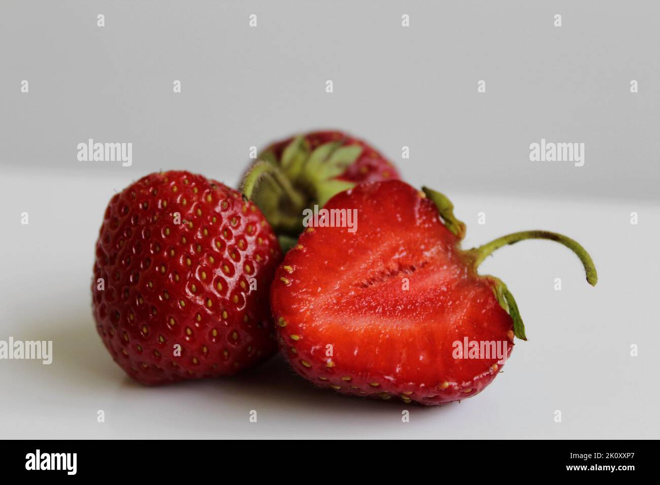 Fresh strawberry whole and cut closeup isolated Stock Photo - Alamy