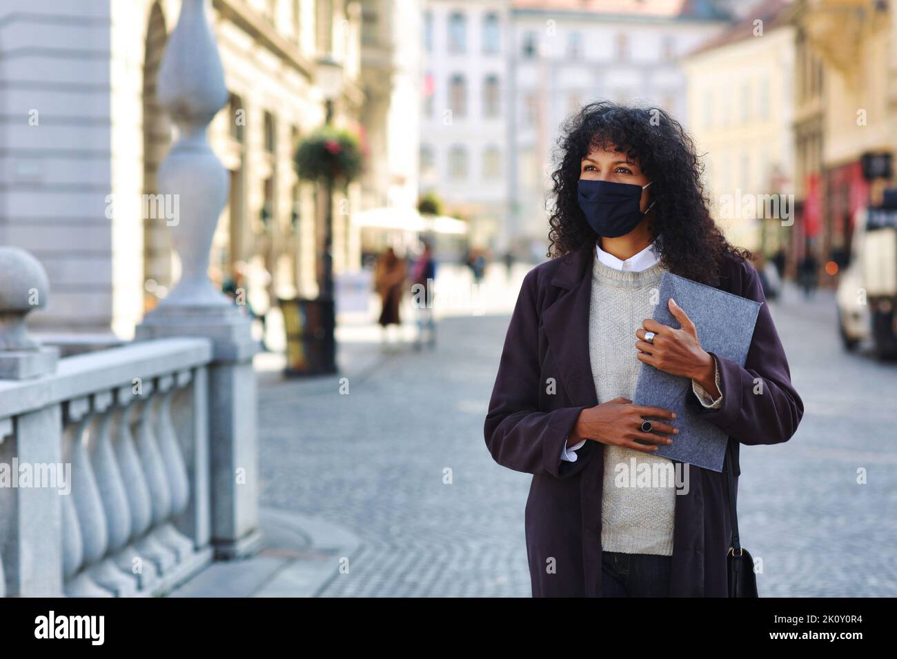businesswoman outdoors with face mask holding folder documents Stock Photo