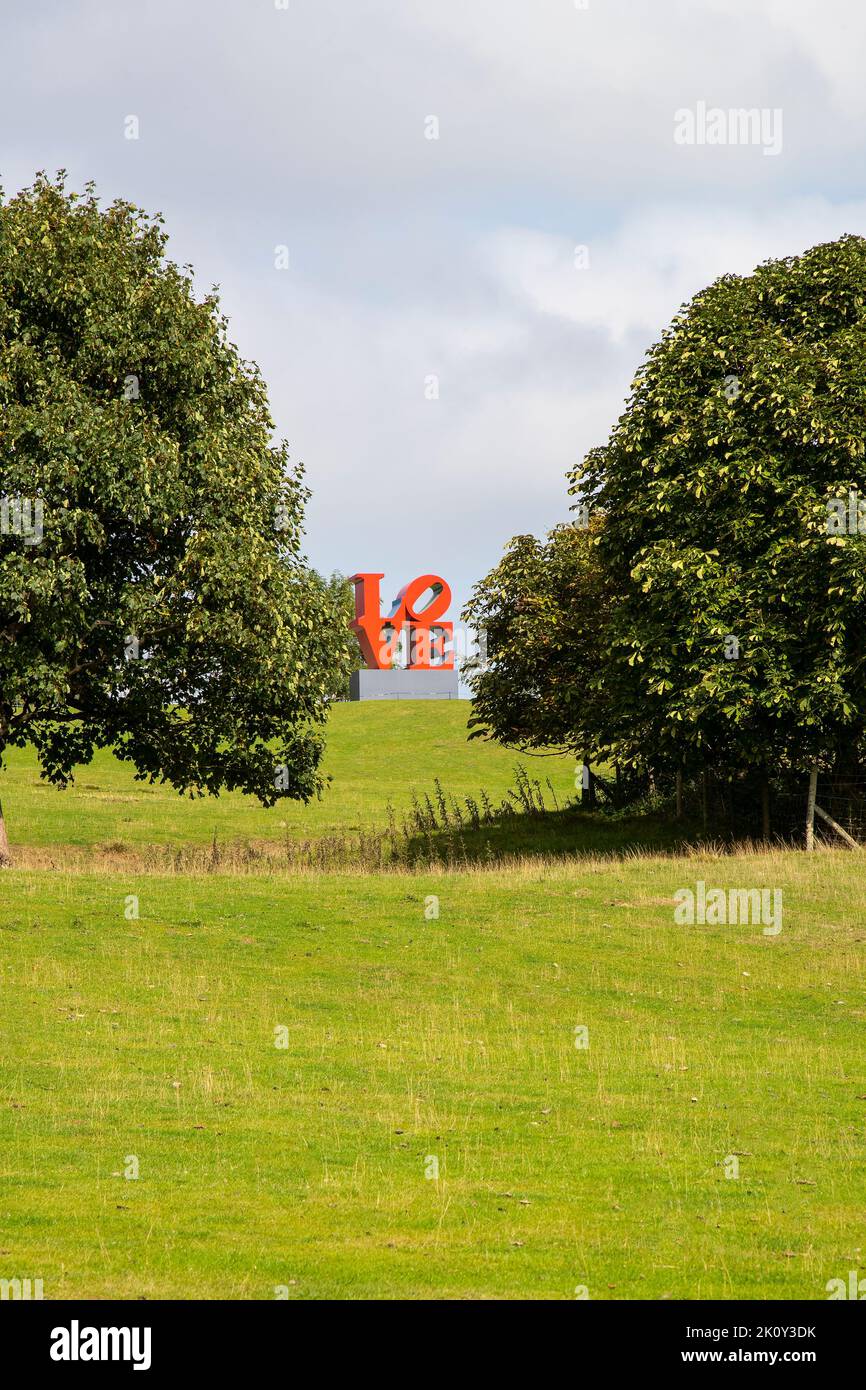 Robert Indiana's iconic LOVE sculpture (Red Blue Green) welcomes visitors to the Yorkshire Sculpture Park using a slanted 'O' in a square format. Stock Photo