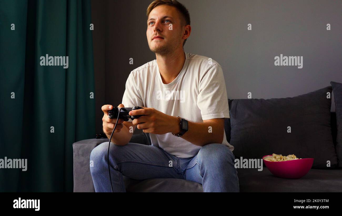 Excited young handsome man playing video game  Stock Photo