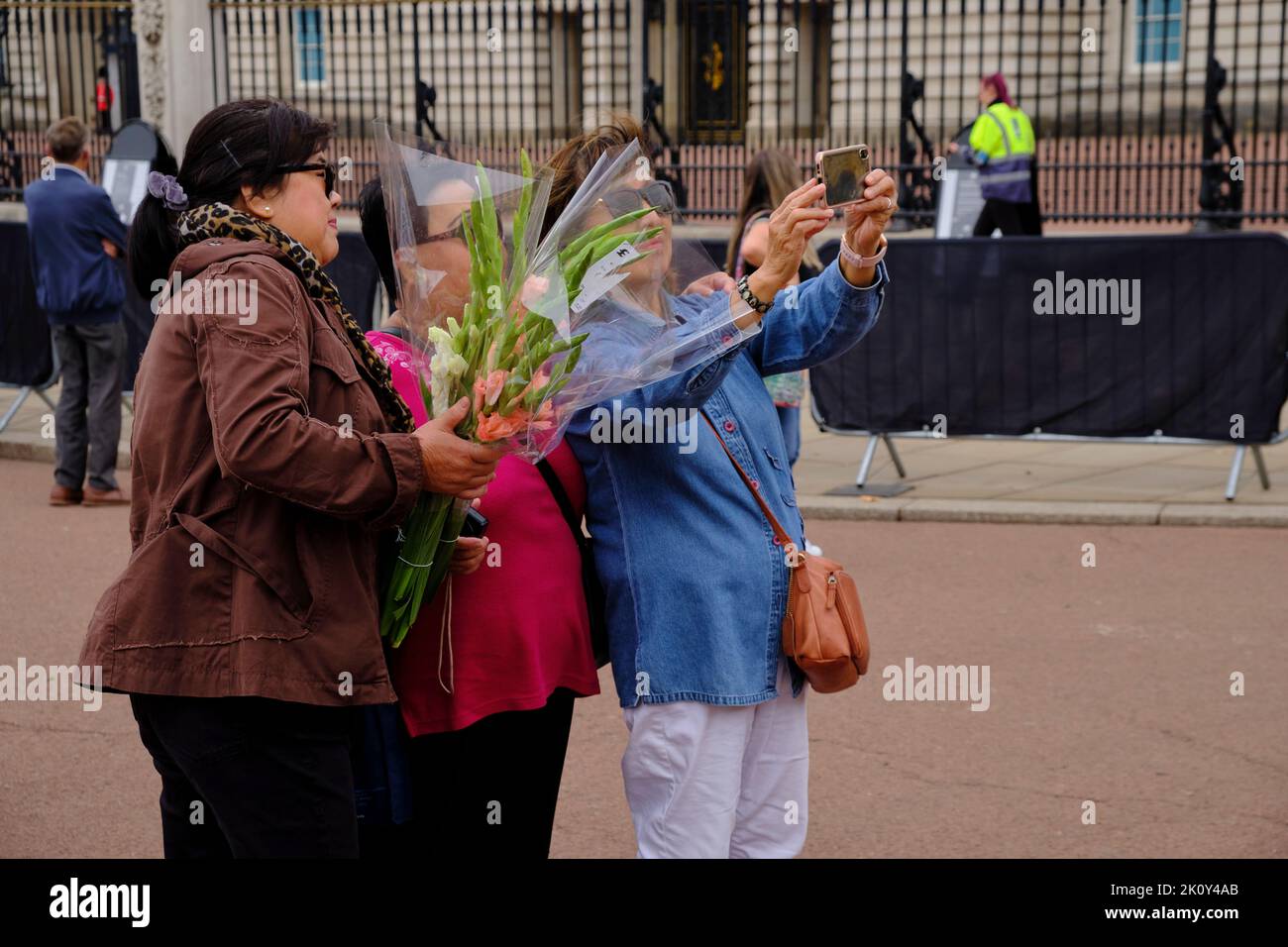Asian Tourists take selfies outside Buckingham Palace following the death of the Queen Stock Photo