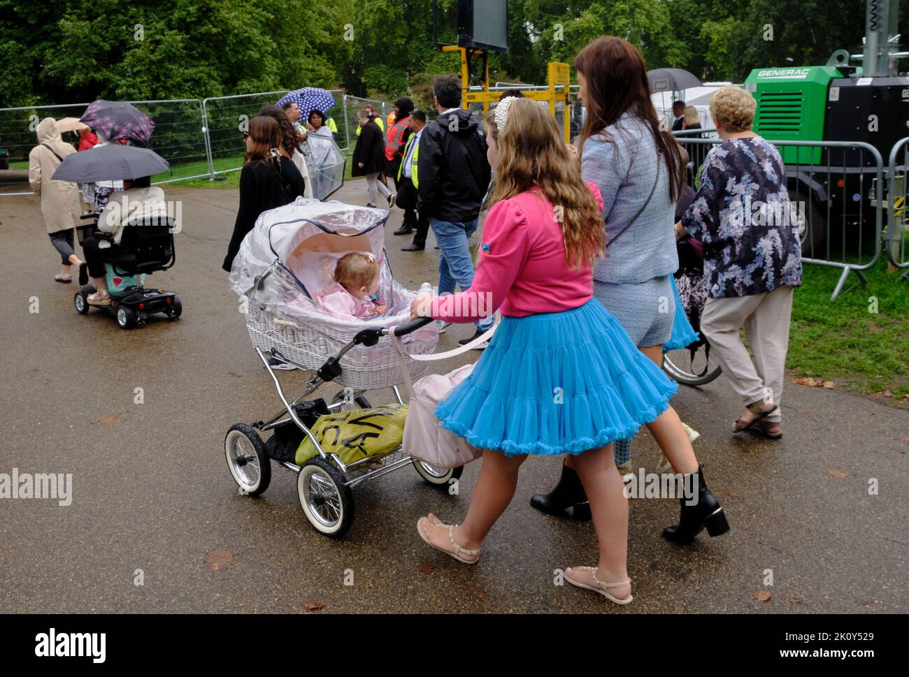 young girl in a tutu pushes a victorian style pram with baby in Green Park London Stock Photo