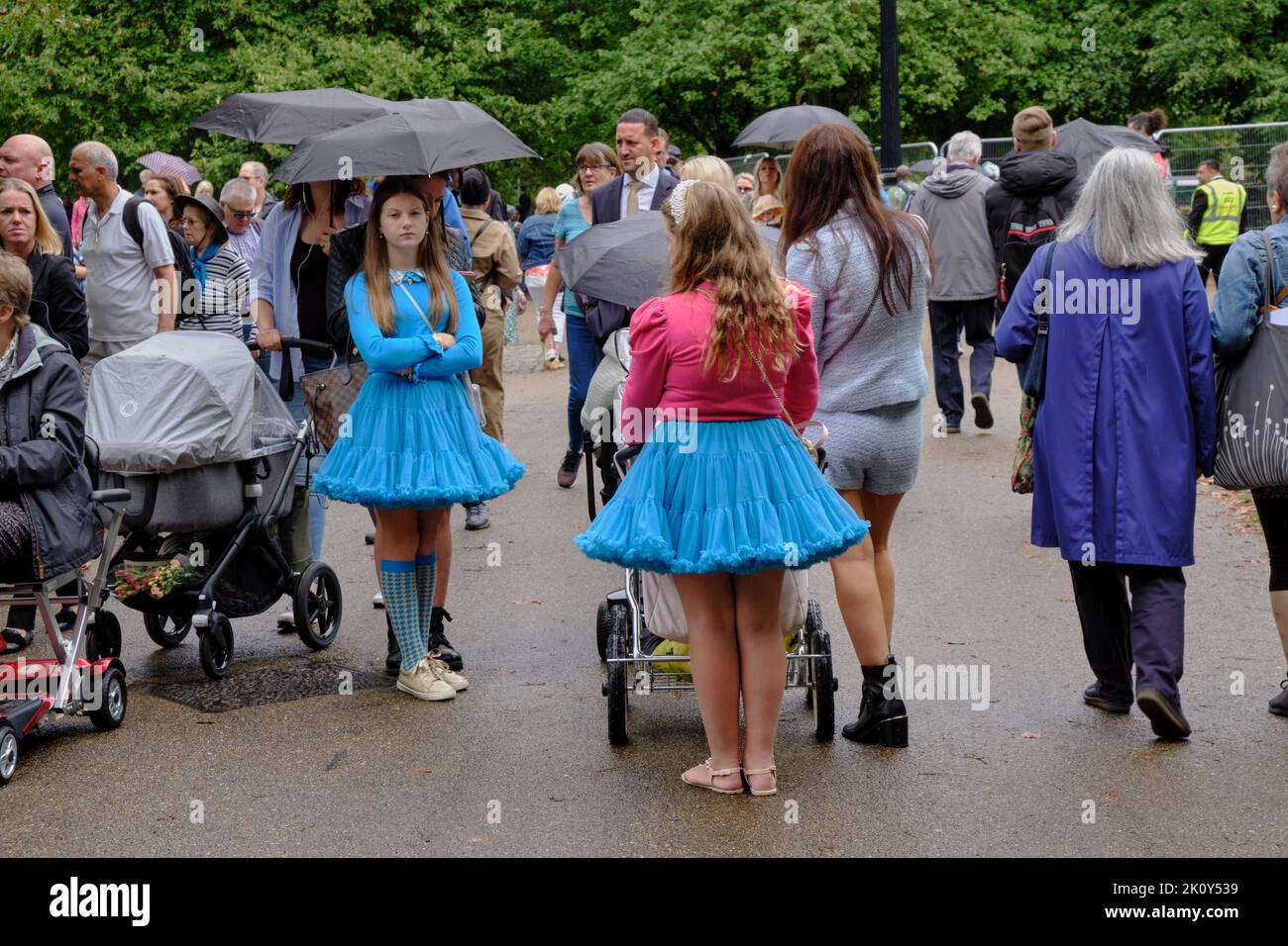young girls in tutus push a victorian style pram with baby in Green Park London Stock Photo