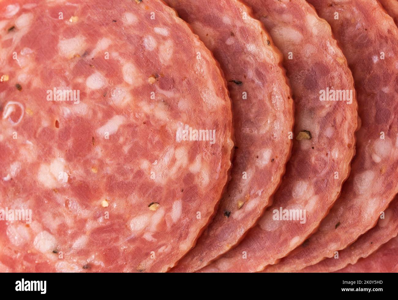 Close view of several slices of dry salami illuminated with natural light. Stock Photo