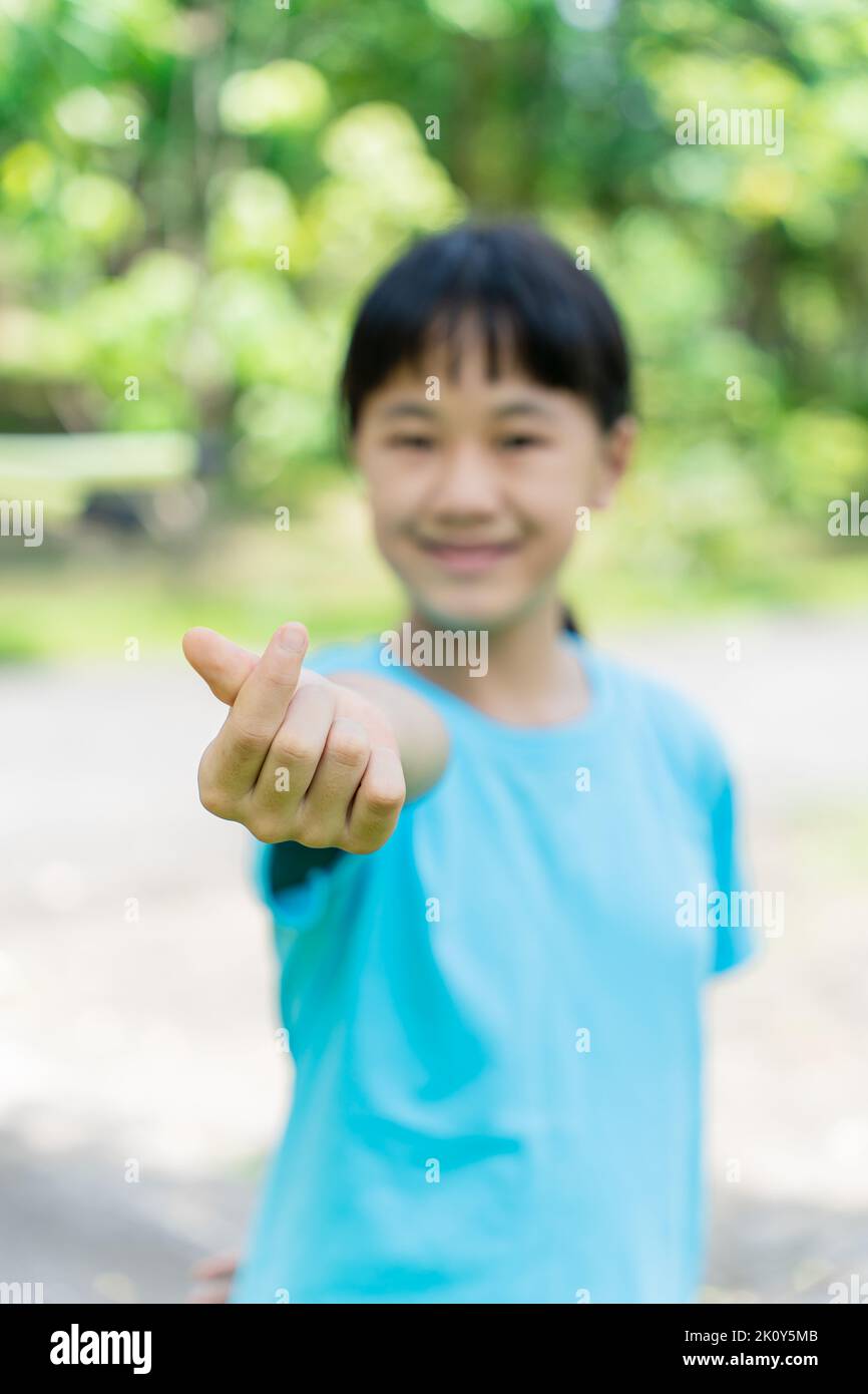 A beautiful child girl making and showing mini heart hand sign. Symbol of love with your fingers Stock Photo