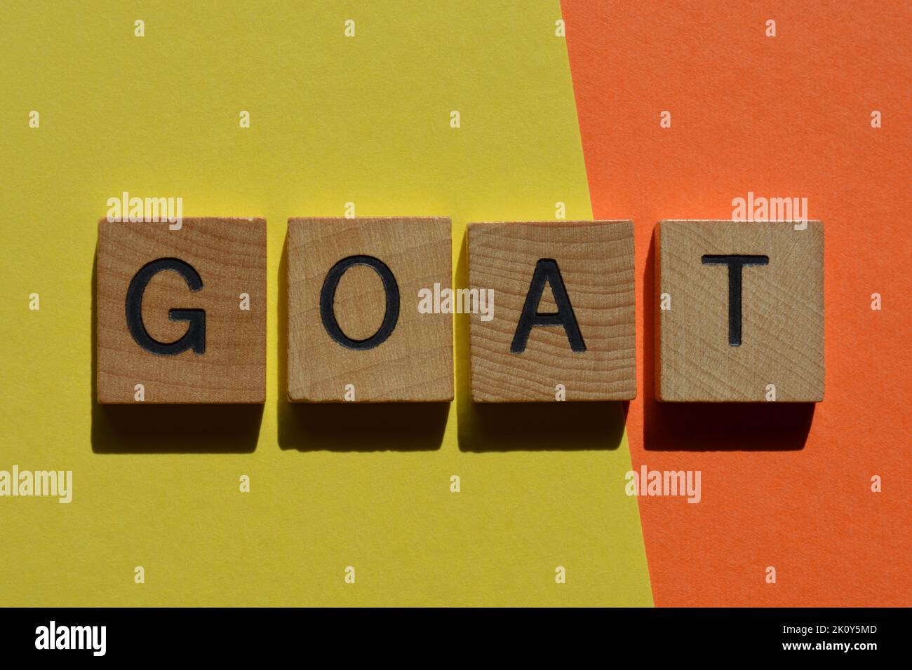 G O A T, acronym for Greatest Of All Time, in wooden alphabet letters isolated on bright and colourful background Stock Photo