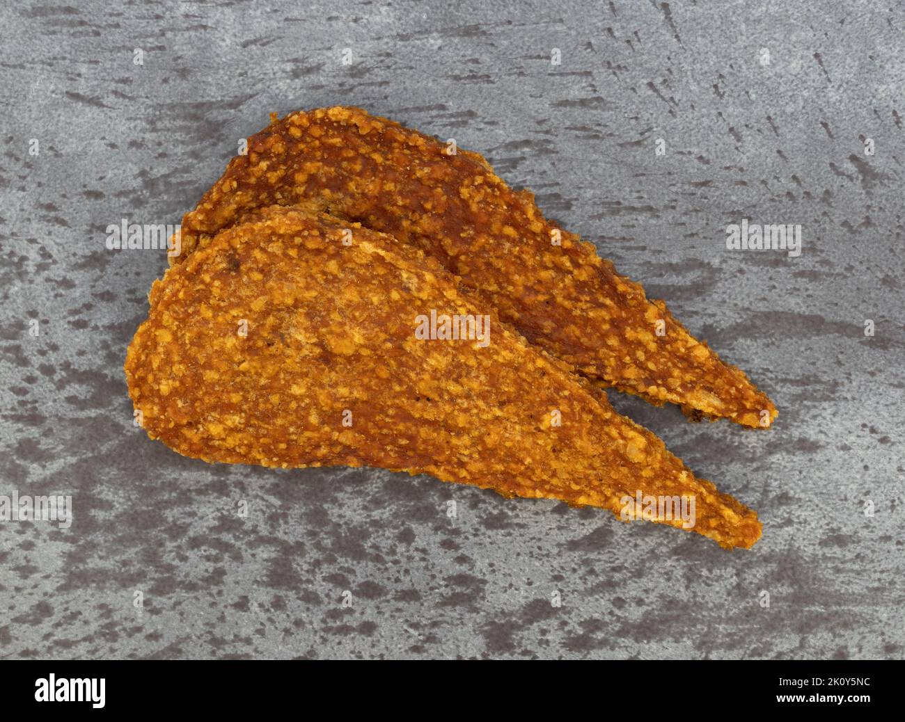 Overhead view of two slices of duck jerky on a gray mottled countertop. Stock Photo