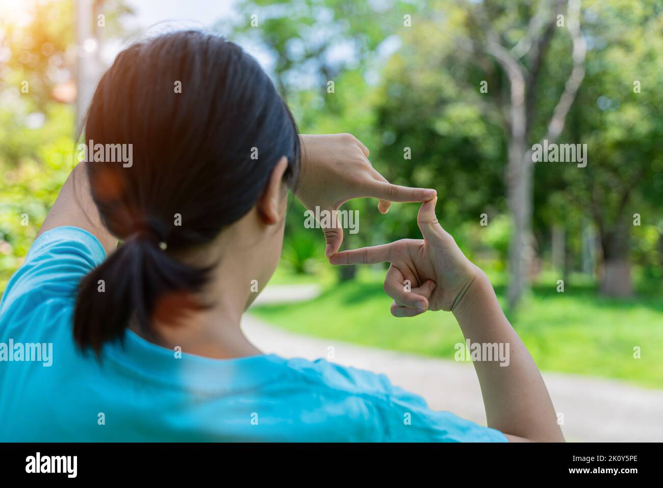 Close up of child girl smiling making frame with hands and fingers. Creativity and photography concept. Stock Photo