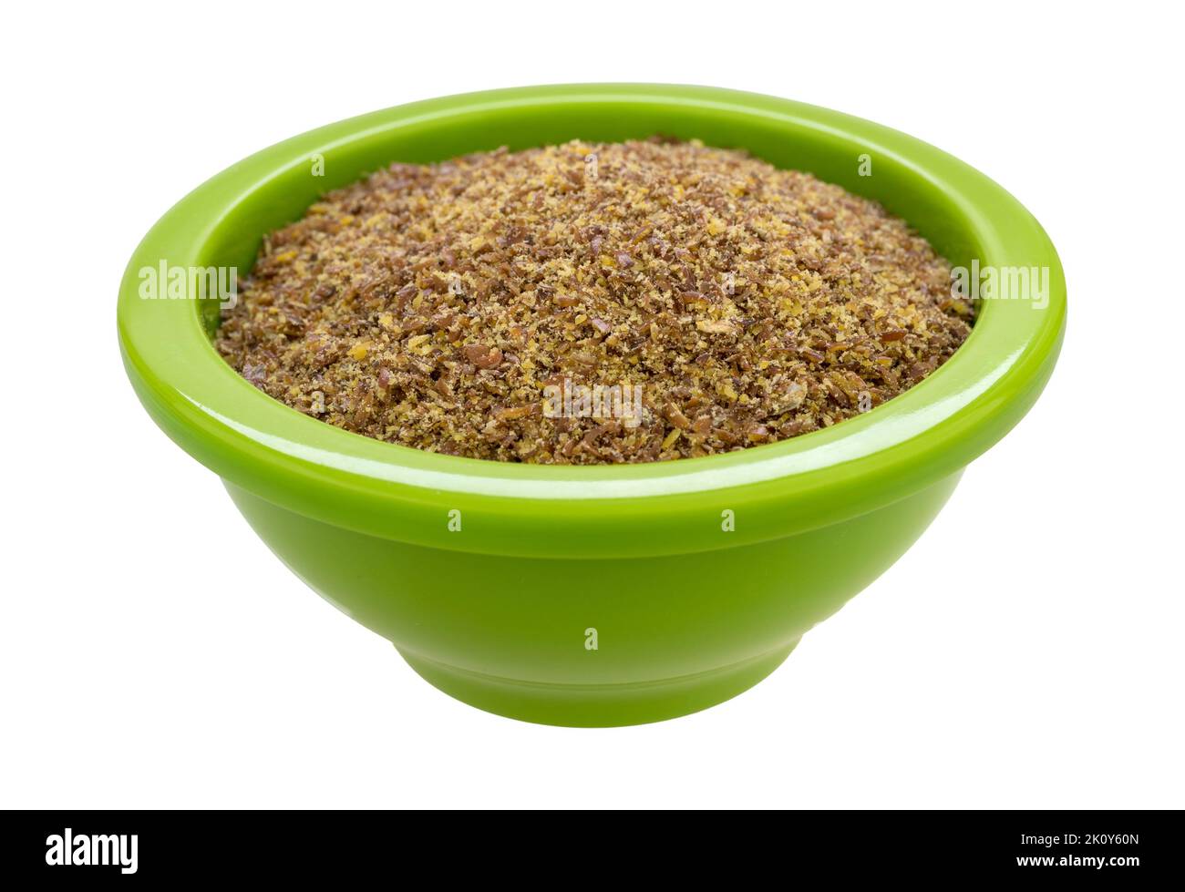 Side view of freshly ground organic flaxseed meal in a green bowl isolated on a white background. Stock Photo