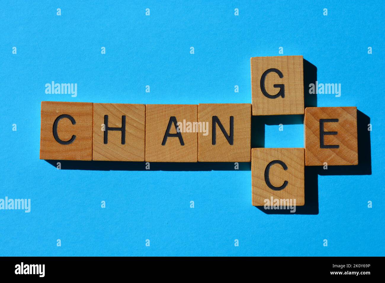 Chance, Change, word play with interchangeable letter C and G, wooden alphabet letters isolated on blue background Stock Photo
