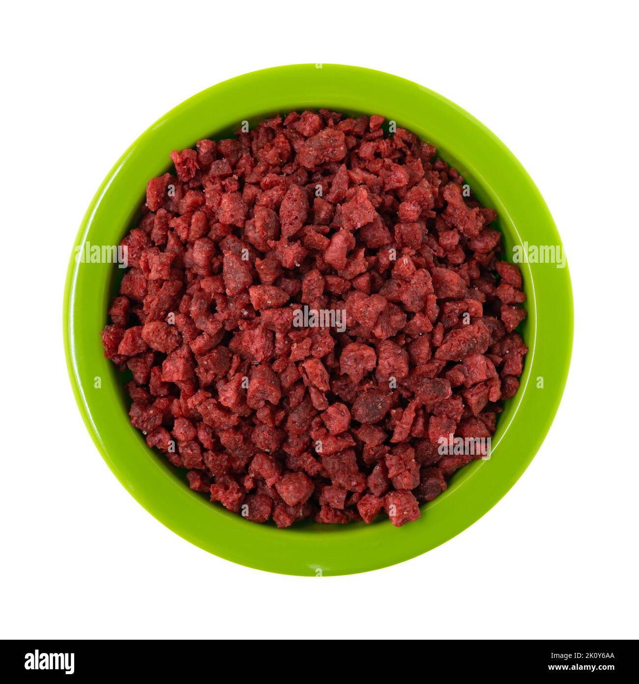 Overhead view of a green bowl filled with imitation bacon bits isolated on a white background. Stock Photo