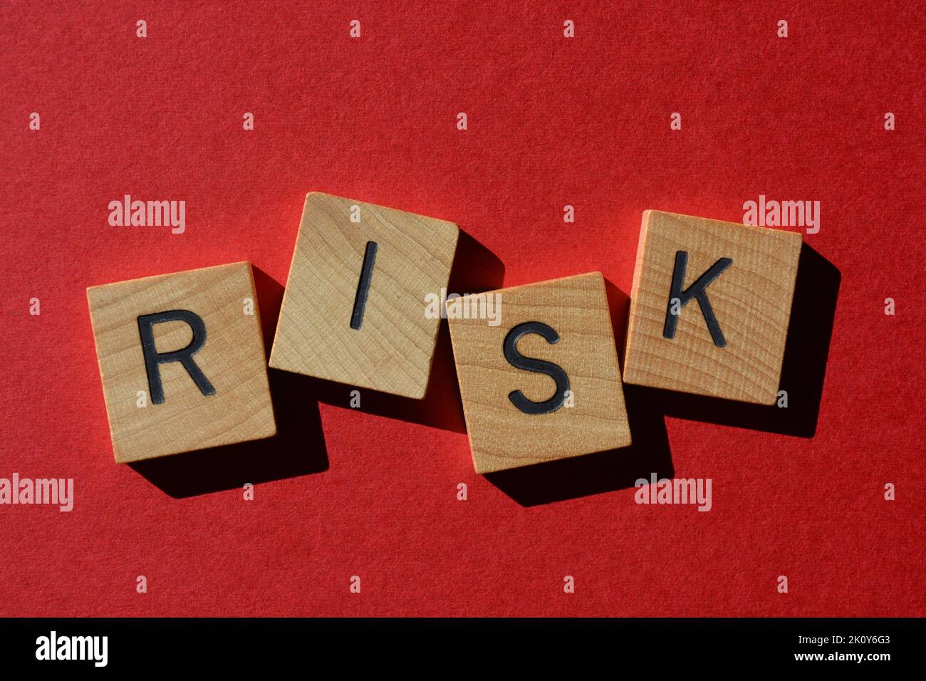 Risk, word in wooden alphabet letters isolated on bright red background Stock Photo