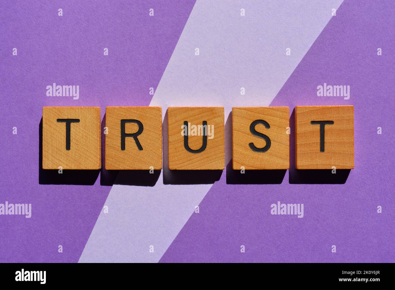 Trust, word in wooden alphabet letters isolated on purple background Stock Photo