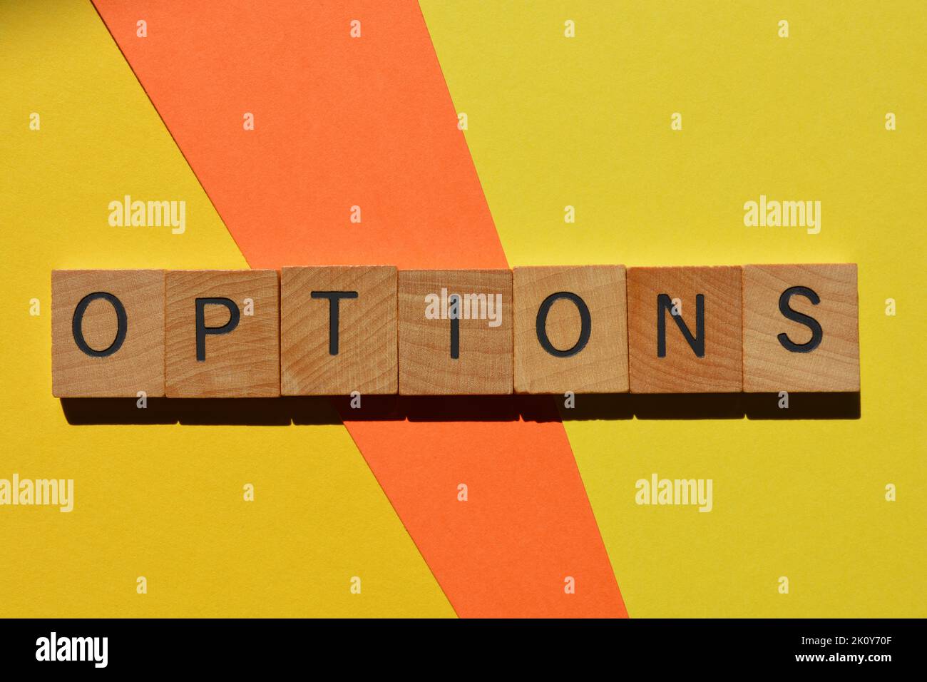 Options, word in wooden alphabet letters isolated on yellow and orange background Stock Photo