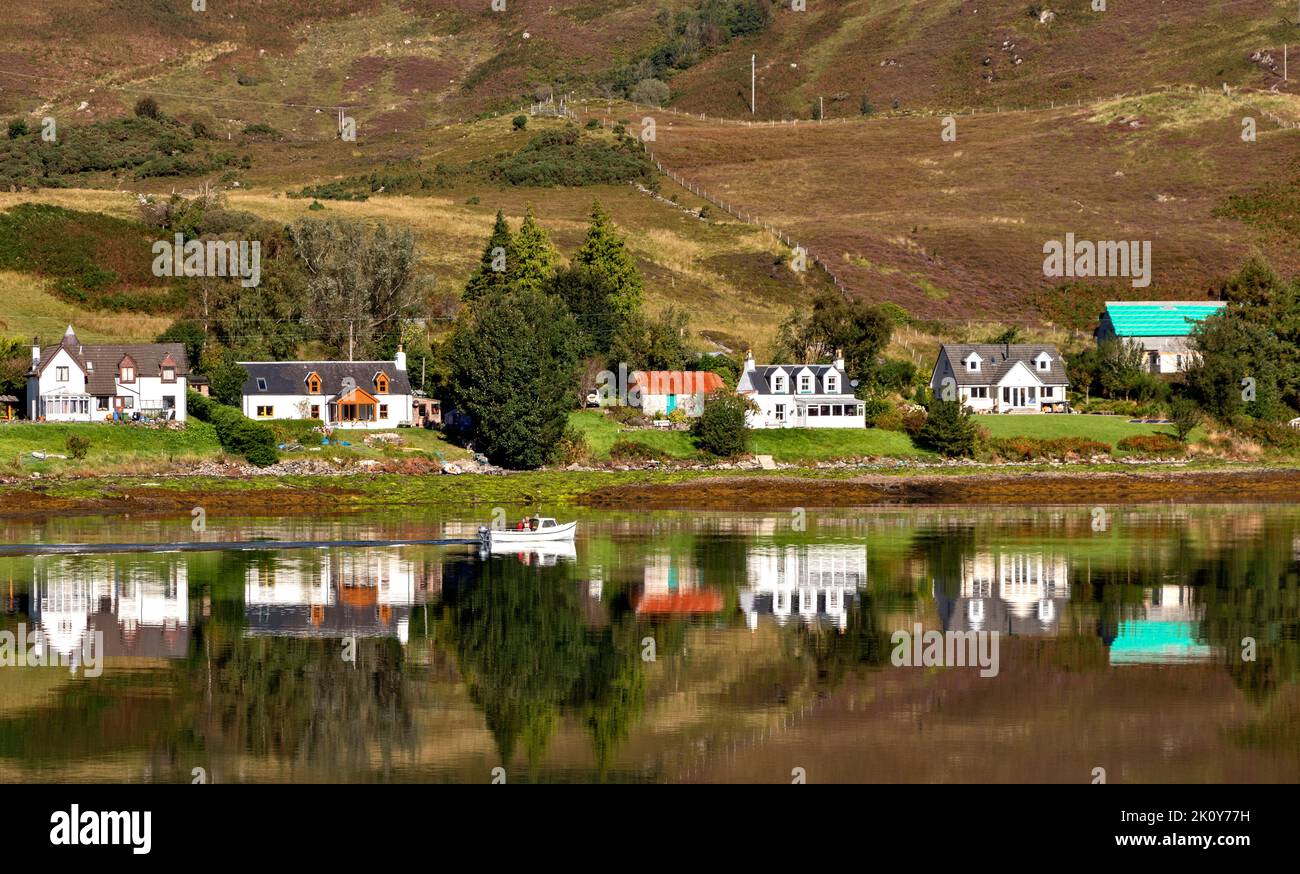 DORNIE KINTAIL SCOTLAND LOOKING ACROSS LOCH LONG TO HOUSES AND A PASSING SMALL FISHING BOAT Stock Photo
