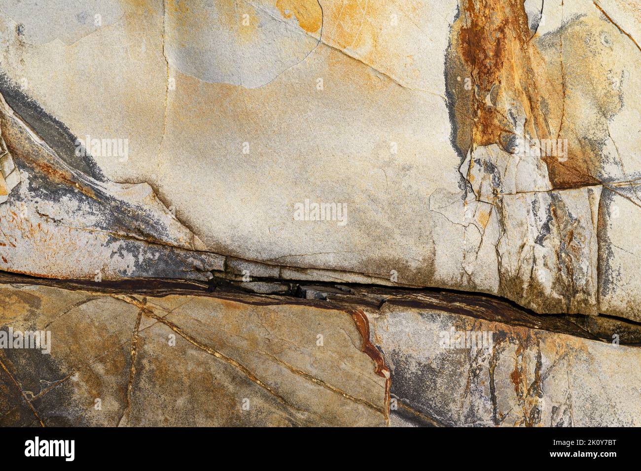 Rock background with cracks and colorful streaks in the early morning light. Stock Photo