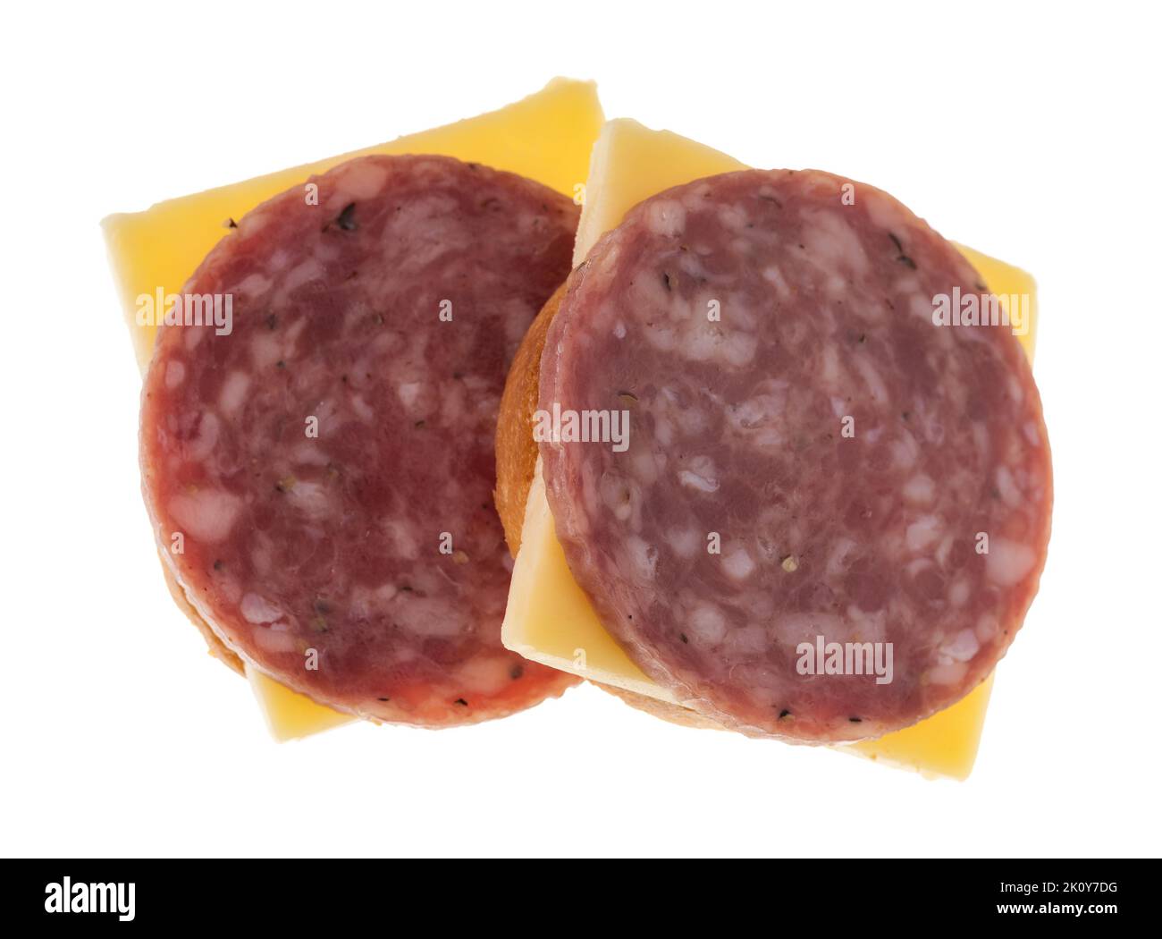 Two snack crackers with dry salami and gouda cheese on a white background. Stock Photo