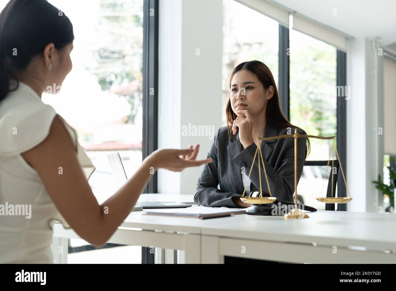 Asian female lawyer discussing negotiation legal case with client meeting with document contact in courtroom, law and justice concept Stock Photo