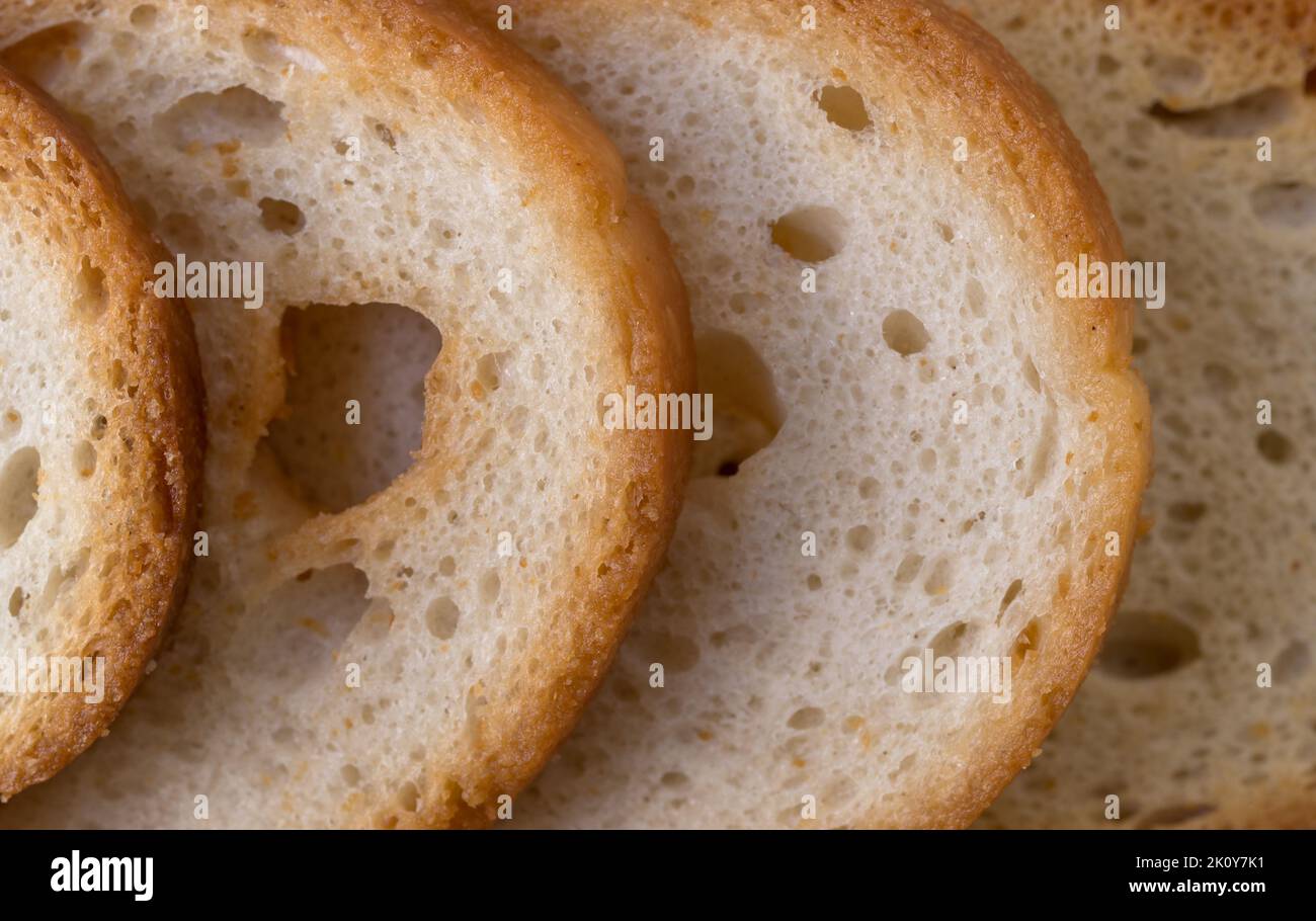 Close view of four slices of toasted round crackers illuminated with natural light. Stock Photo
