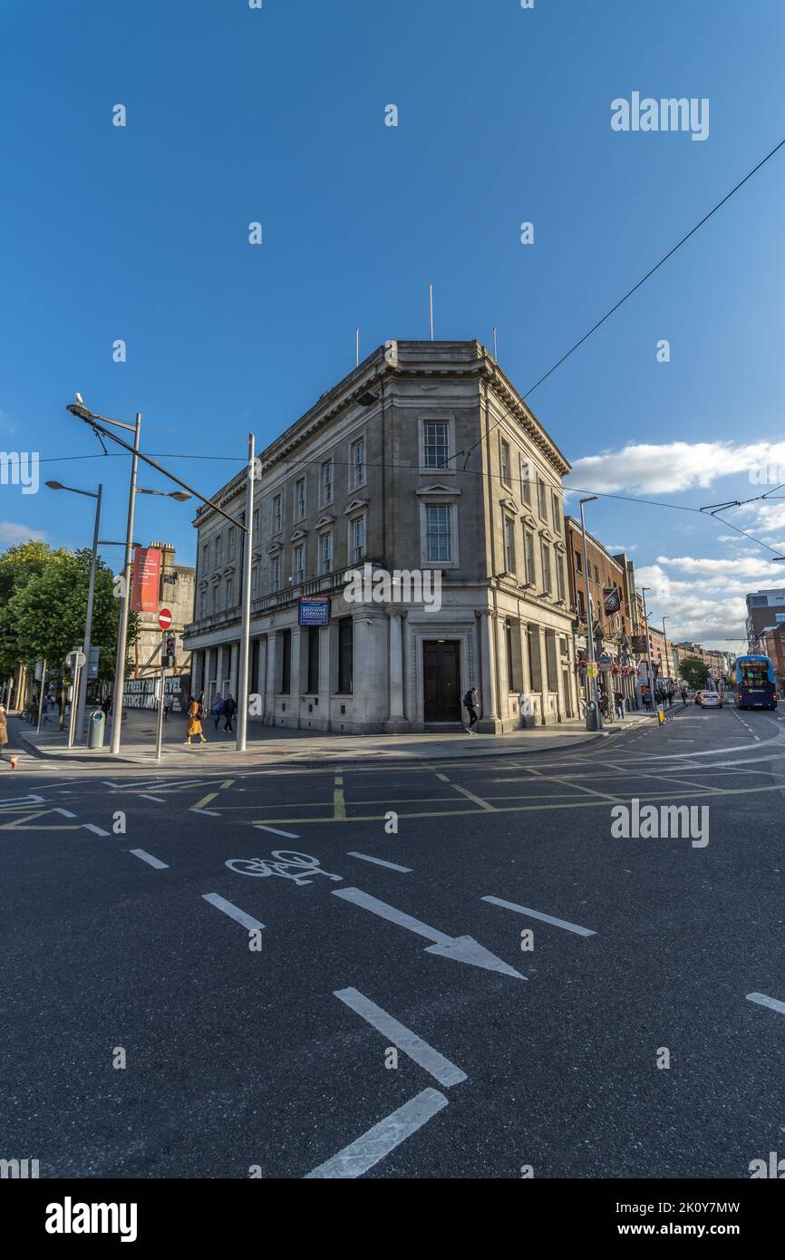 An angle shot of the old AIB bank branch from the corner with road signs visible on asphalt, Dublin, Ireland. Stock Photo