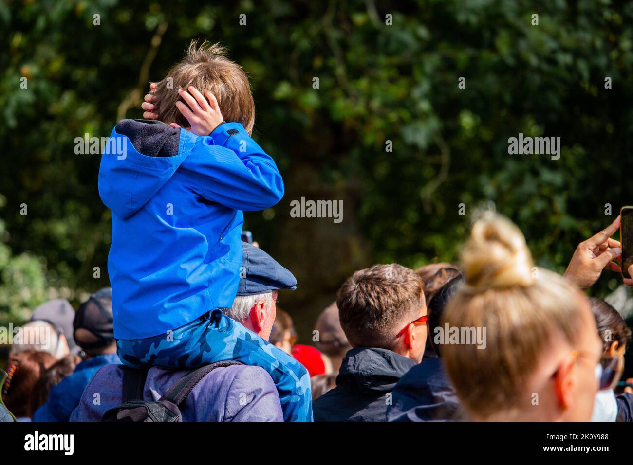 A boy covers his ears during a military gun salute in Hyde Park after