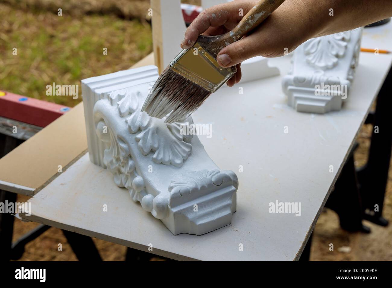 Painting wooden corbels for the kitchen island with worker is using paintbrush Stock Photo