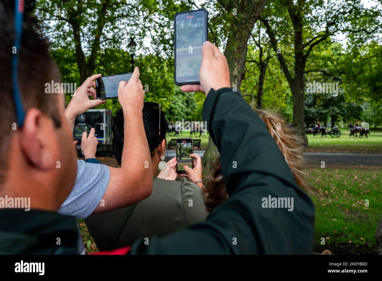 People take pictures of a gun salute in Hyde Park the day after the