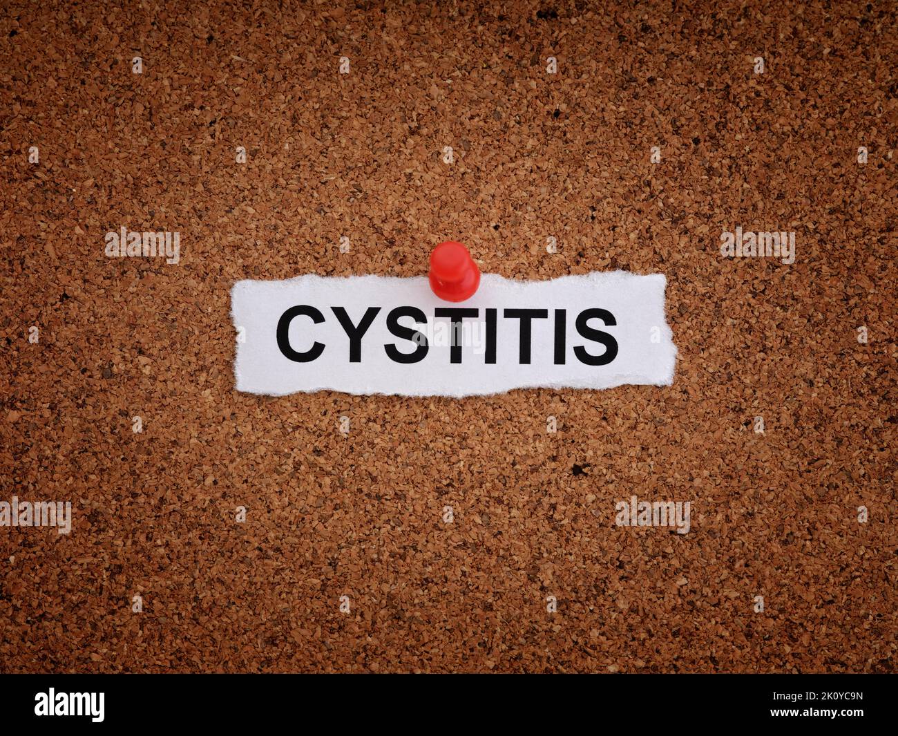 A piece of paper with the word Cystitis on it pinned to a cork board. Close up. Stock Photo