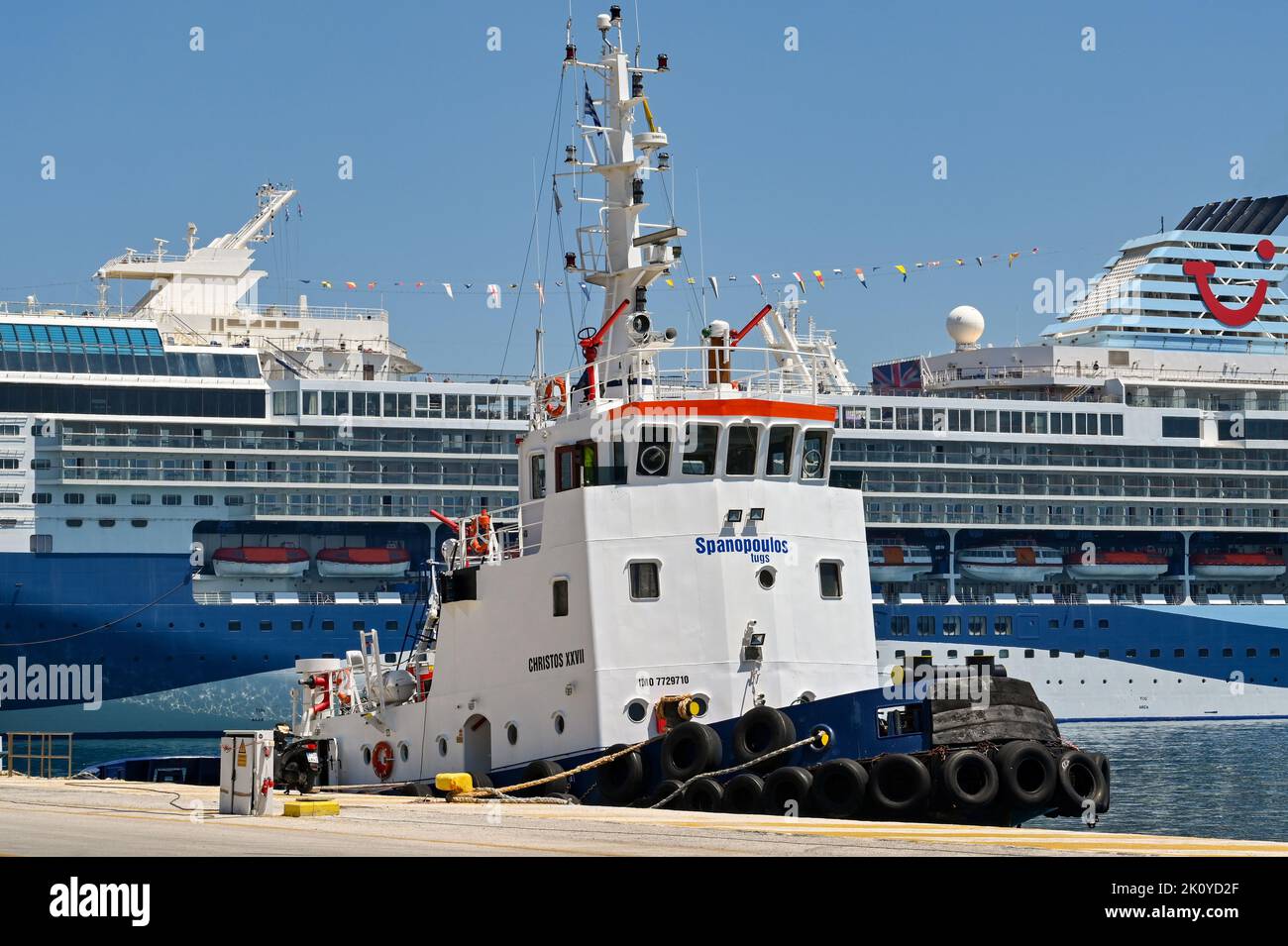 Corfu, Greece - June 2022: Firefighting tug moored in the port of Corfu with a cruise ship in the background Stock Photo