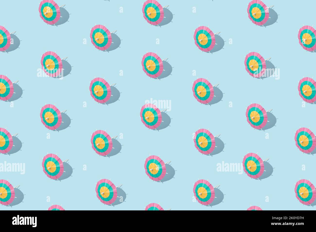 Summer pattern - paper cocktail umbrellas on blue background. Minimal concept. Stock Photo