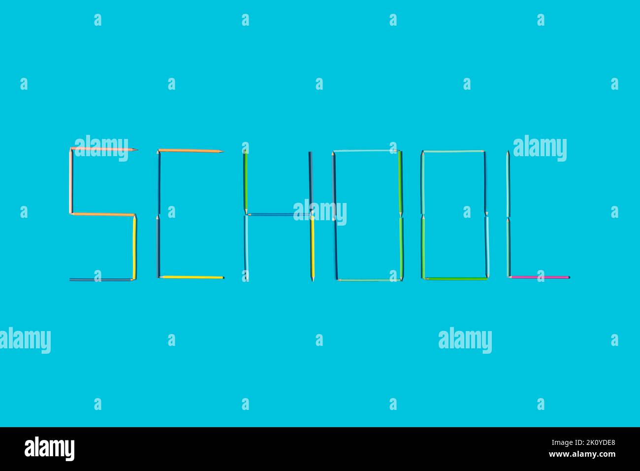 Word school written / made with crayons on blue background. Minimal concept. Stock Photo