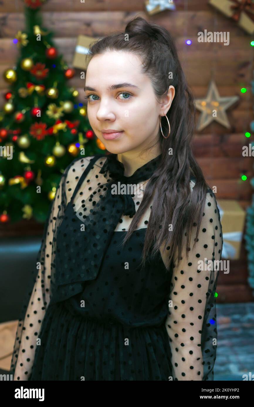 A teenager girl with black hair celebrates Christmas her house. Stock Photo