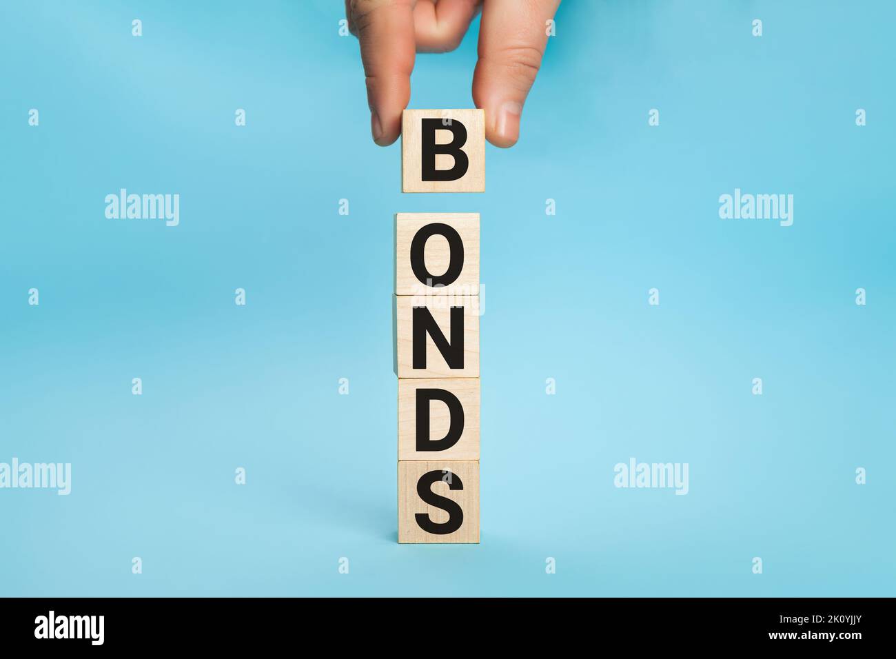 Concept of bonds. Businessman puts wooden blocks with the word Bonds. Equivalent loan. Unsecured and secured bonds. Bonds increasing concept. Copy Stock Photo