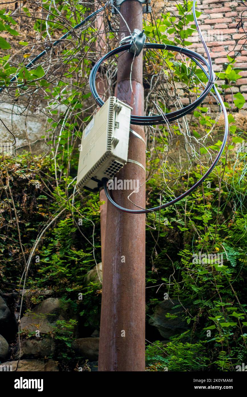 April 13th 2022, Dehradun City Uttarakhand India. JiO Fiber optics 5g Internet service distribution box with connections on an electric pole. Stock Photo