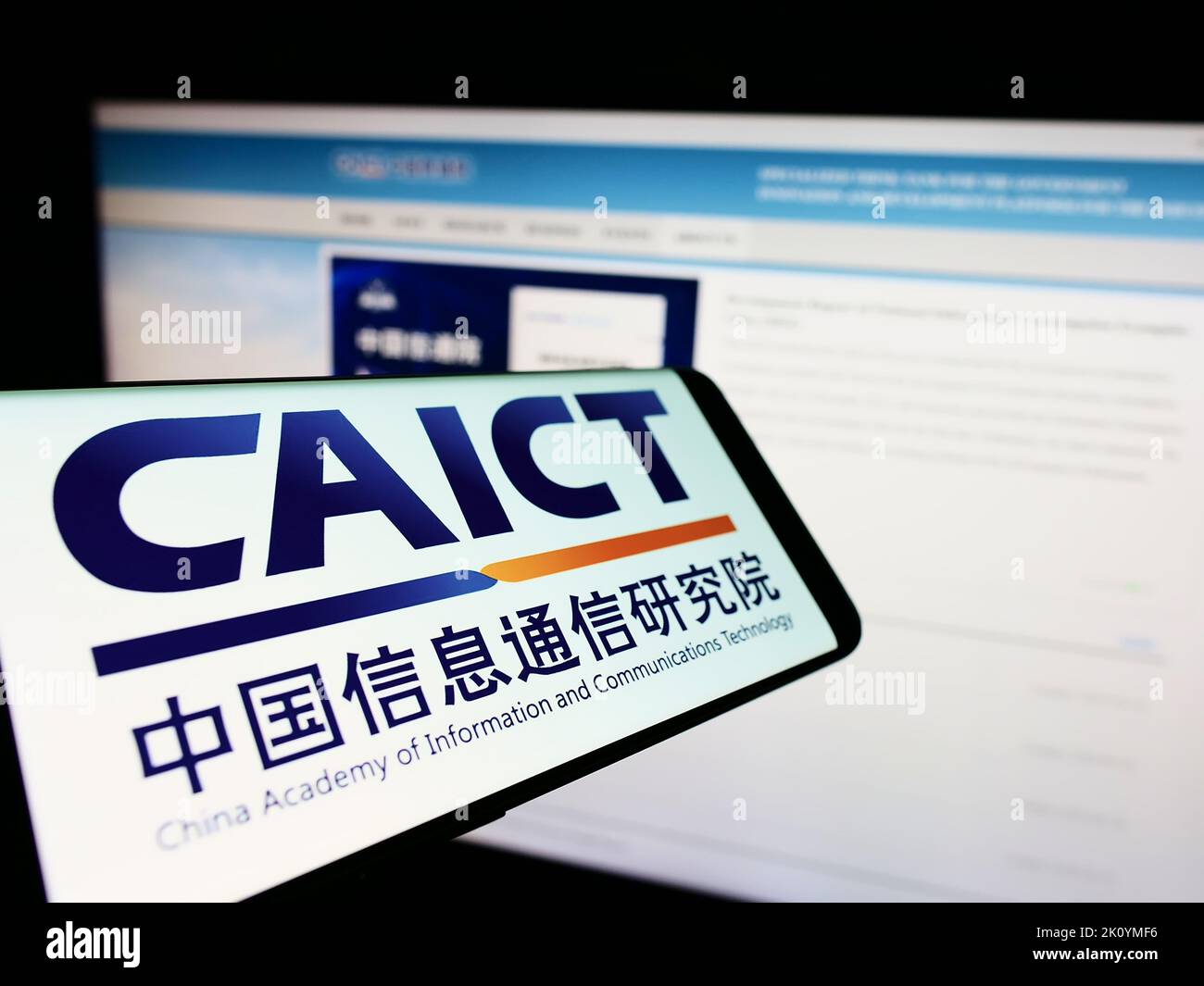 Smartphone with logo of Chinese communications research institute CAICT on screen in front of website. Focus on center of phone display. Stock Photo