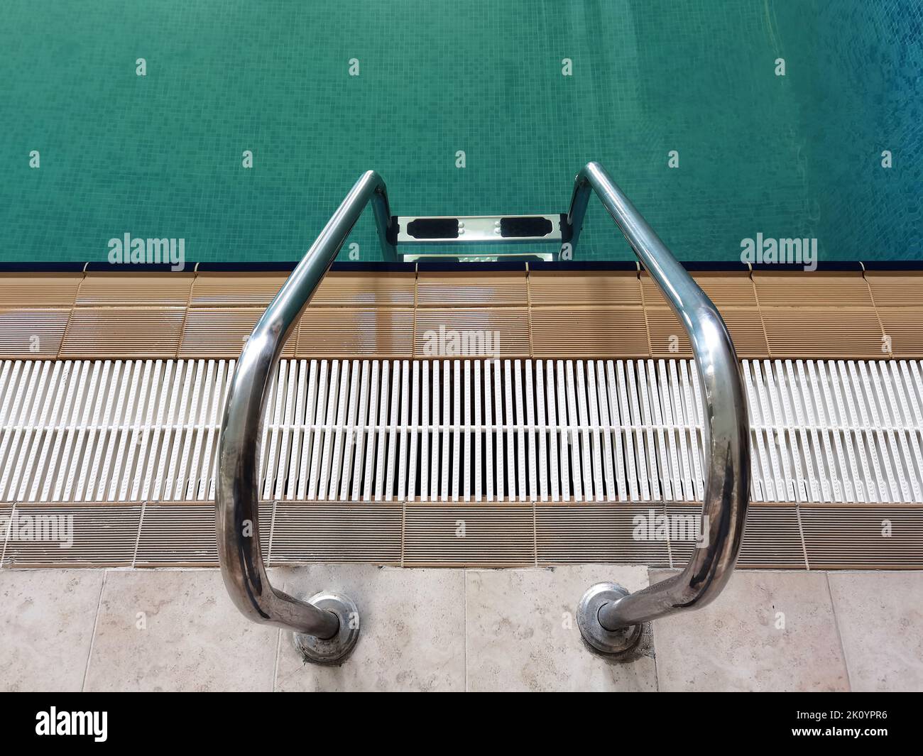 Handrail on pool. Swimming pool with stair at tropical resort. Top view ...