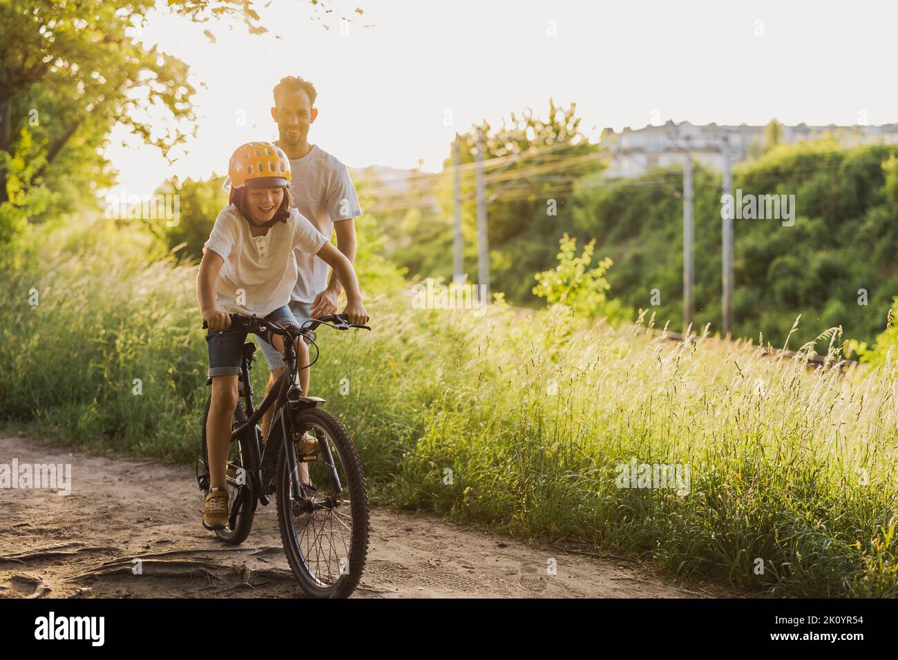 Father teaching his son how to ride a bicycle Stock Photo