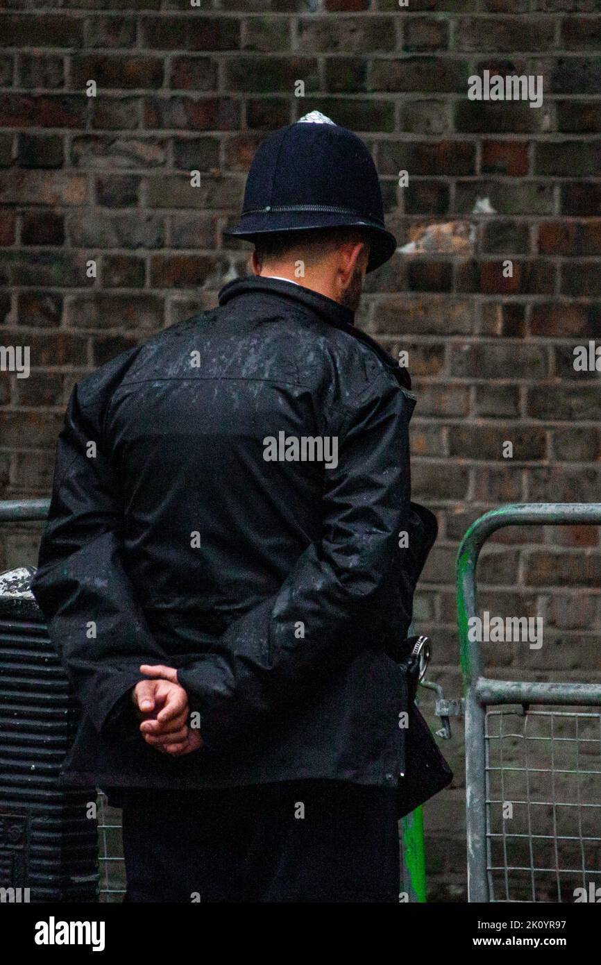 A police officer stands vigil at the roadside as Queen Elizabeth II's