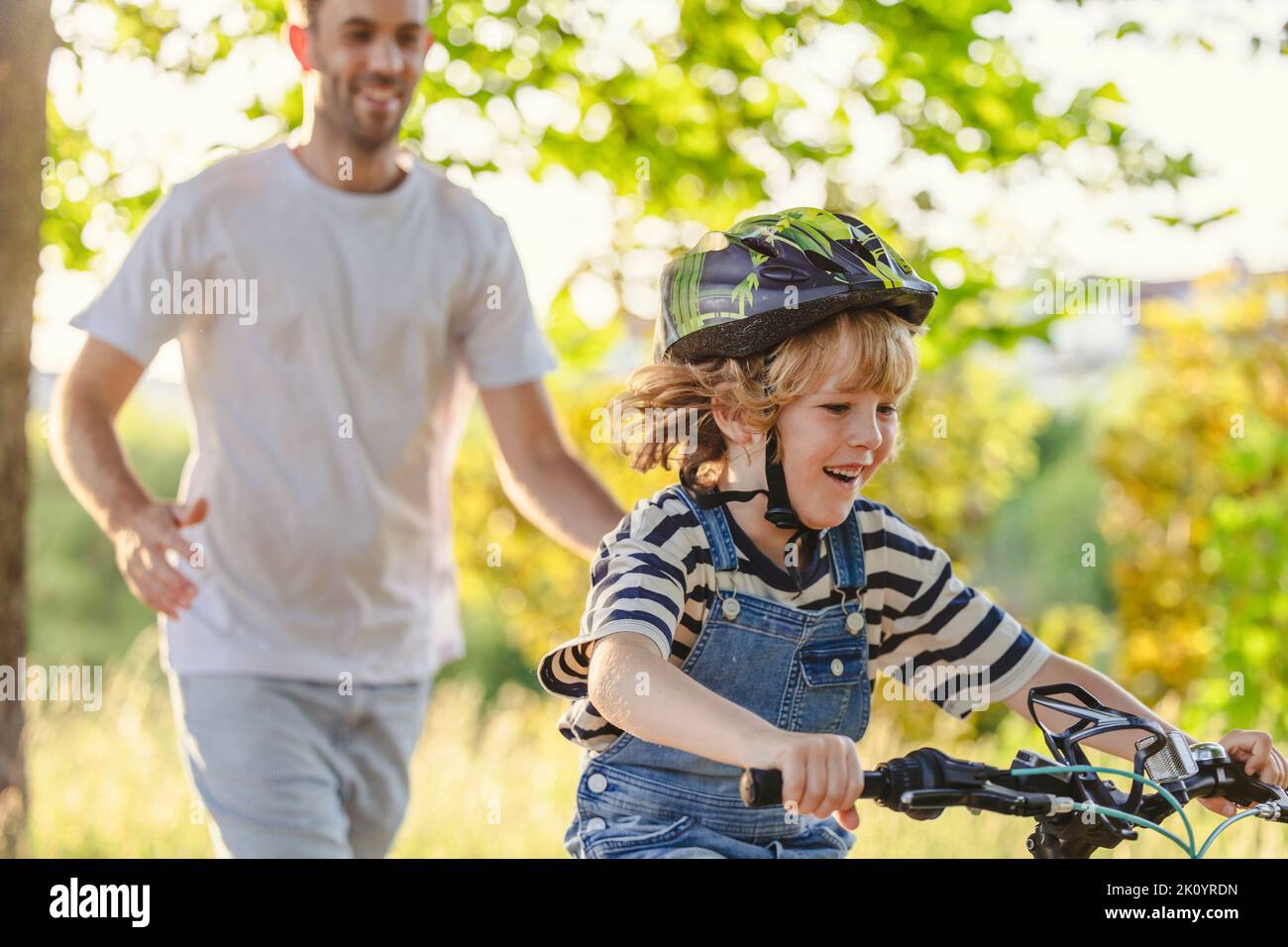 Father teaching his son how to ride a bicycle Stock Photo