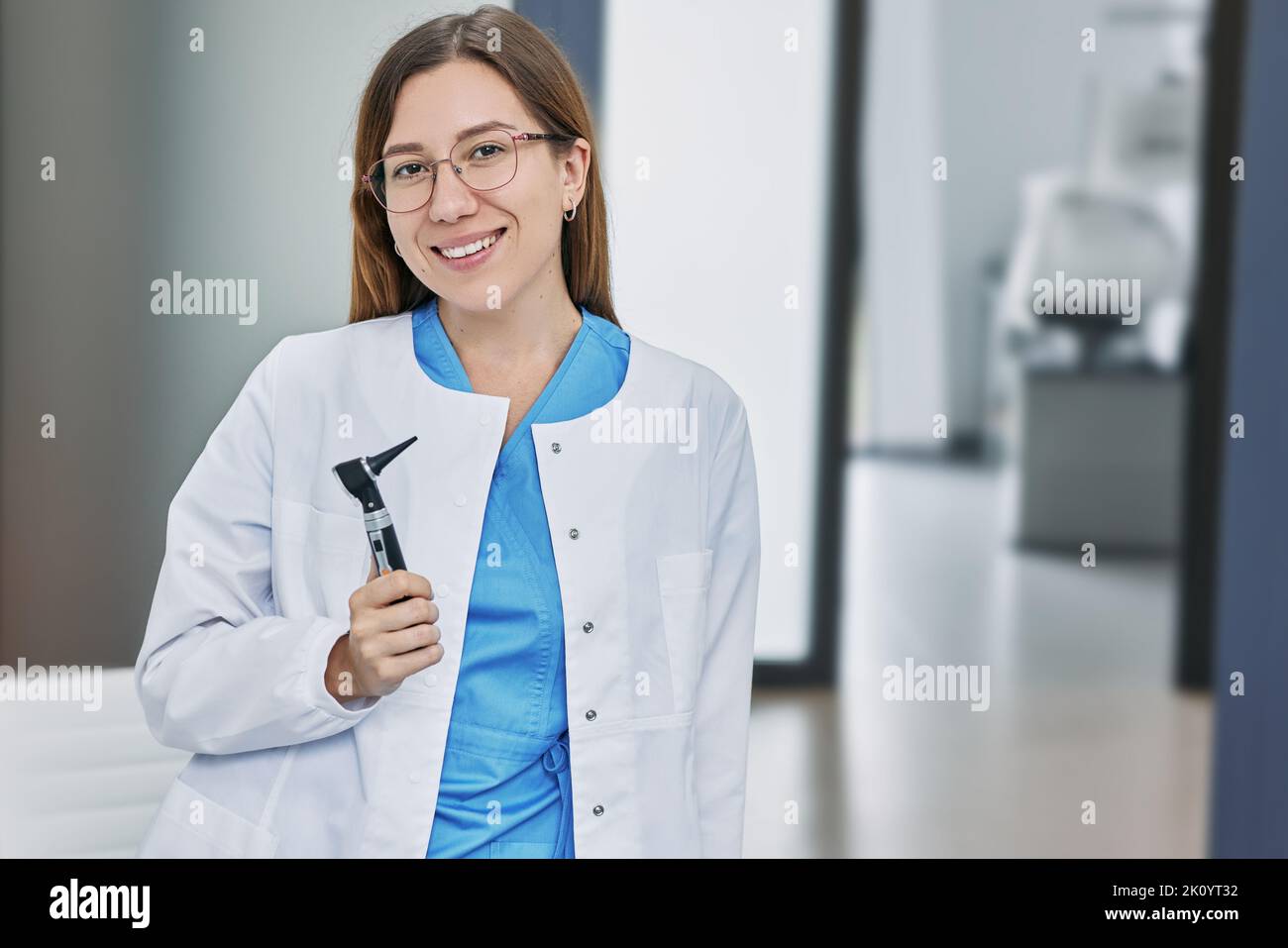 Portrait of female audiologist with otoscope standing in hearing clinic Stock Photo